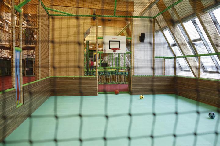 Überdachter Ballspielplatz mit Basketballkorb und Spielfläche für Fußball und Ballspiele im Monki Park.