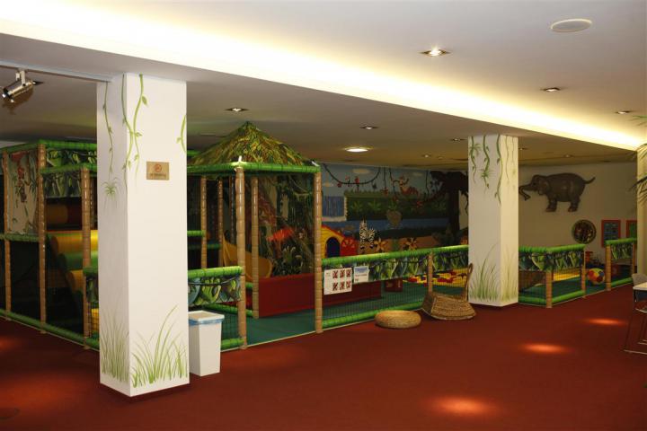 Geschützter Indoor-Spielbereich für Kleinkinder mit altersgerechten Spielgeräten und weichen Spielflächen.